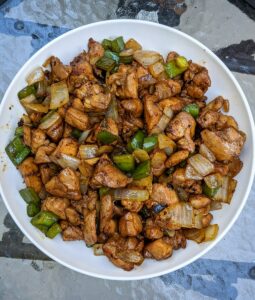 This is a photo of small pieces of black pepper chicken cut up and in a white bowl.