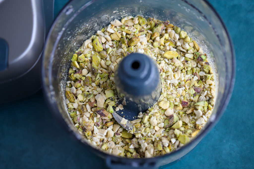 This is a photo of pistachios and cashews in the food processor