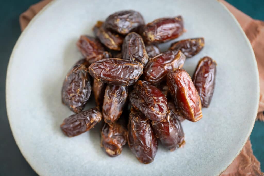 This is a photo of medjool dates on a grey plate