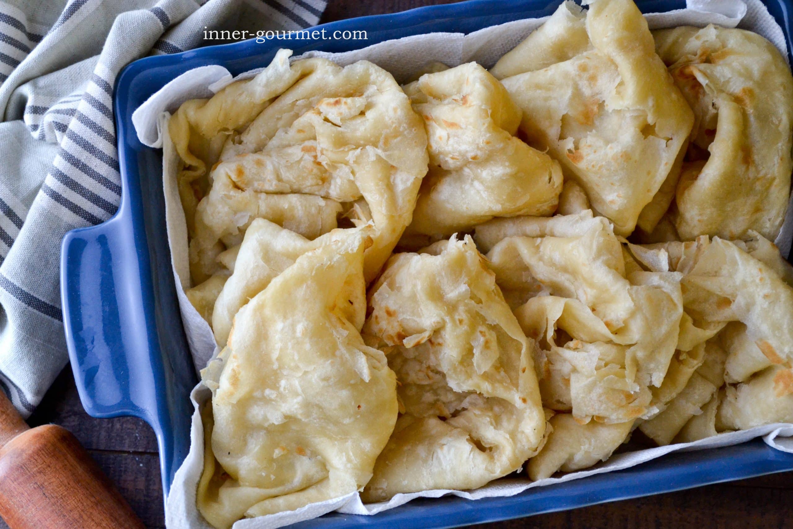 This is an image of Guyanese oil roti in a blue dish folded after cooking