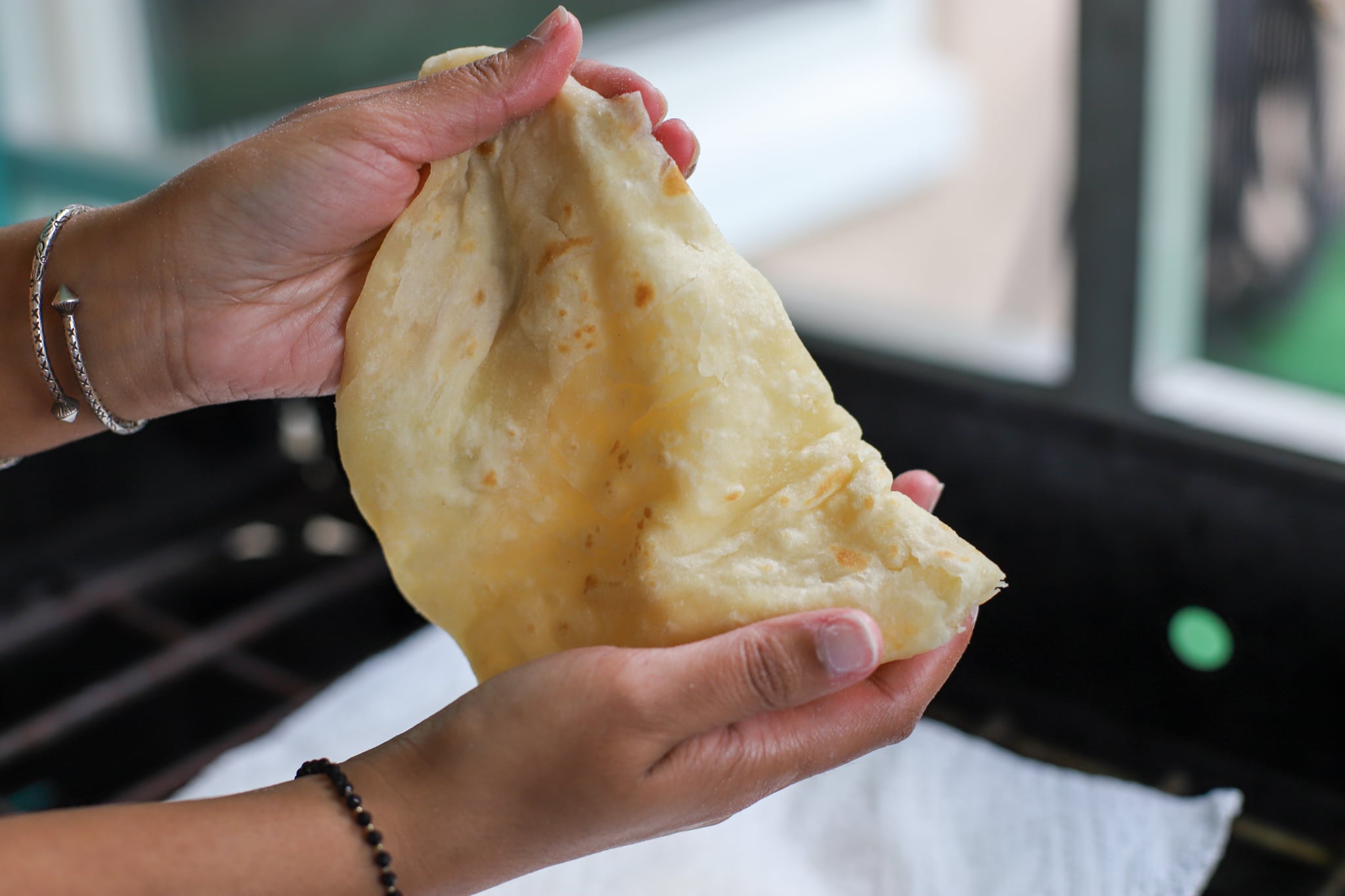 clapping the roti with two hands to release layers