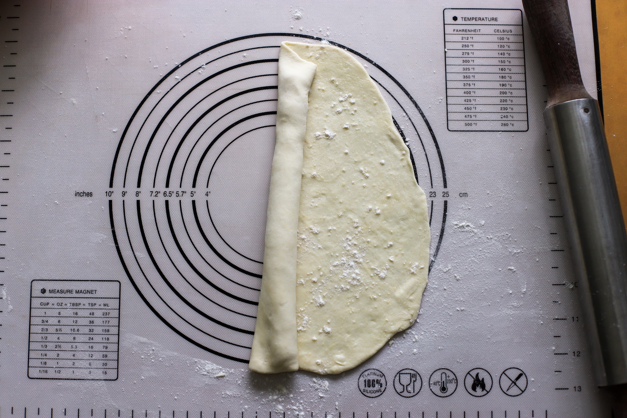 dough being rolled up to form a loi