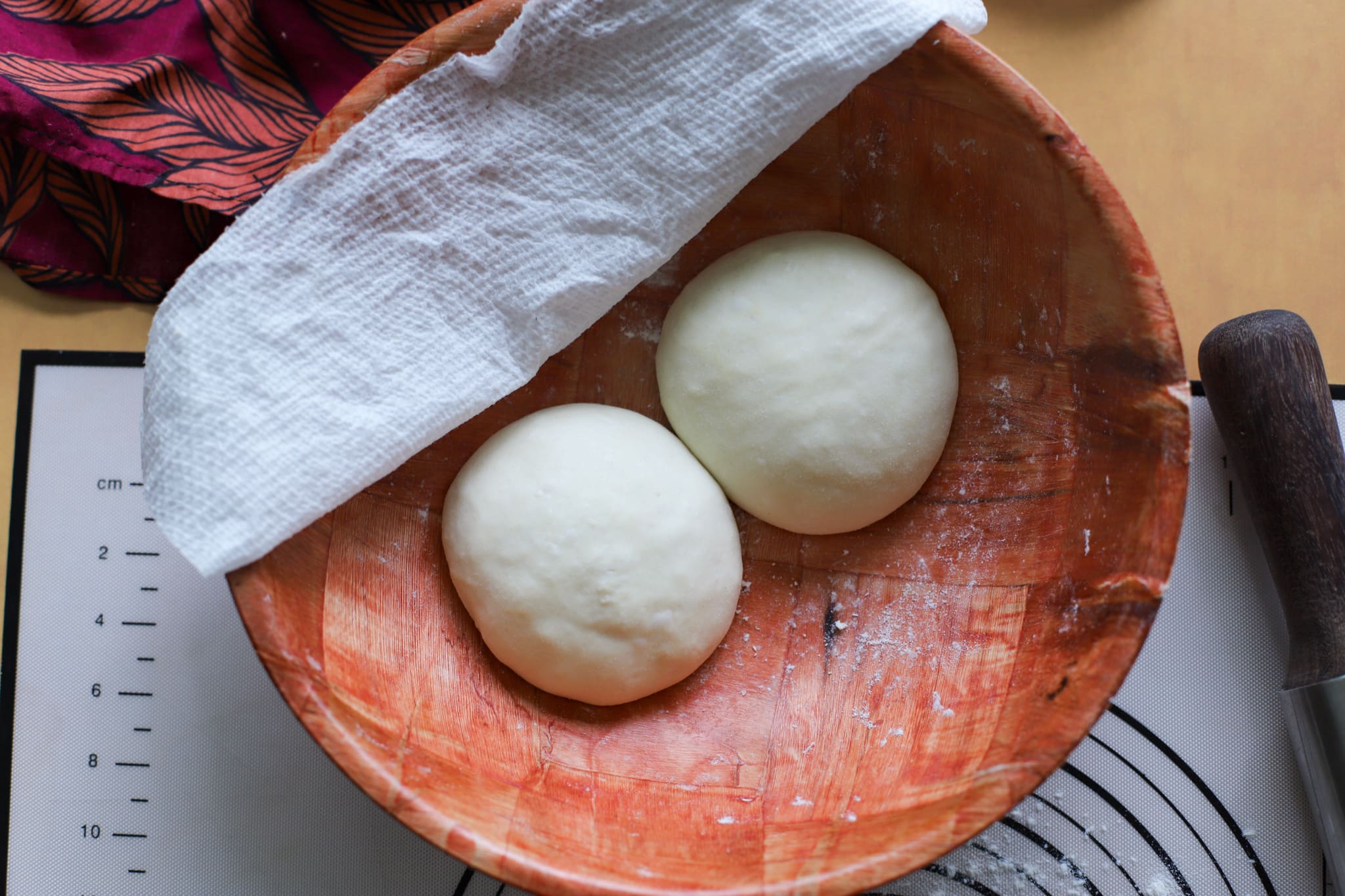 two dough balls after resting in wooden bowl
