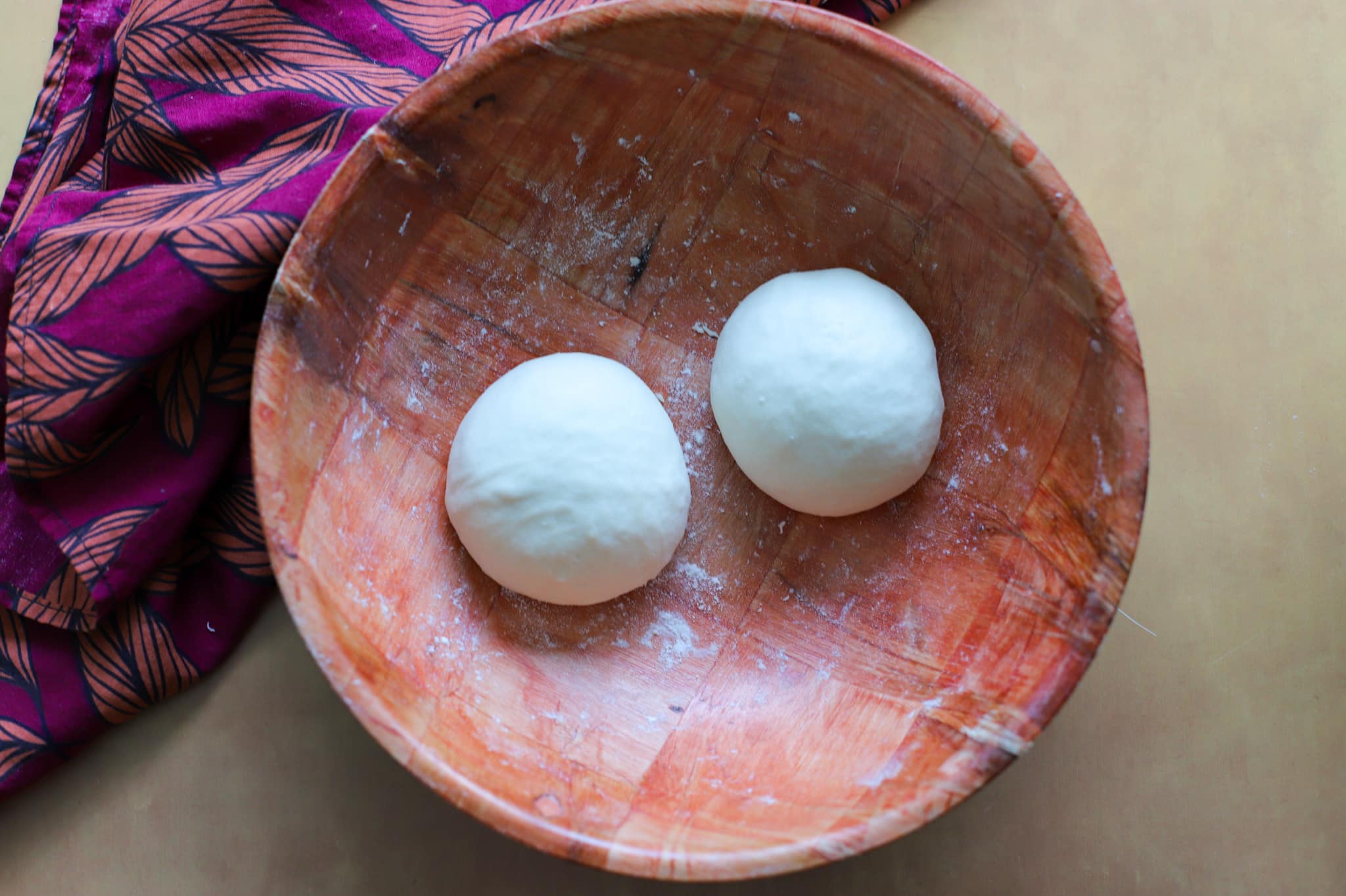 wooden bowl with two smaller dough balls