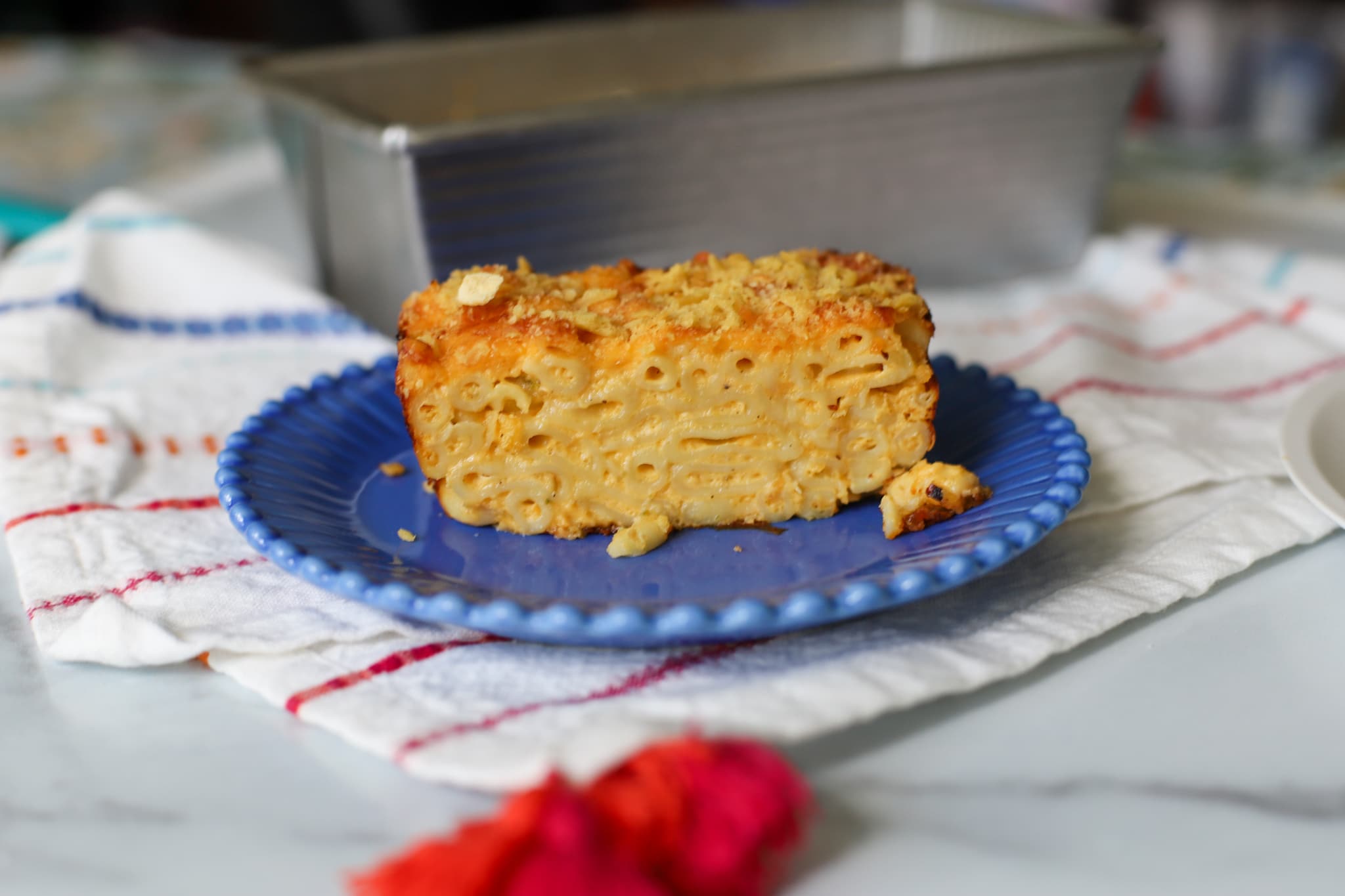macaroni pie sliced after coming out the oven served in a blue plate