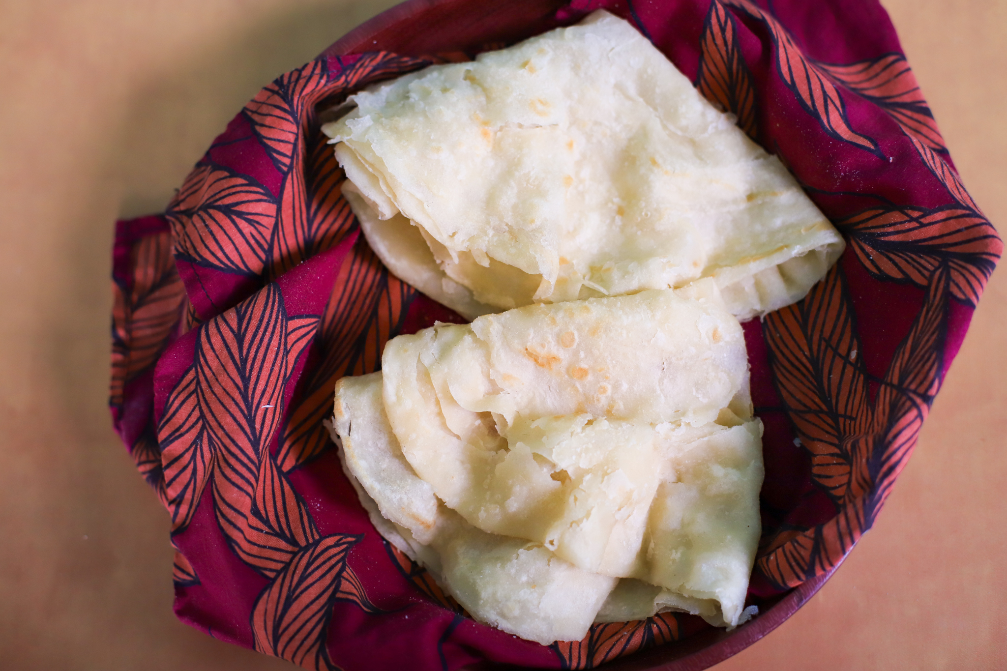 two guyanese oil rotis in a bowl for small batch