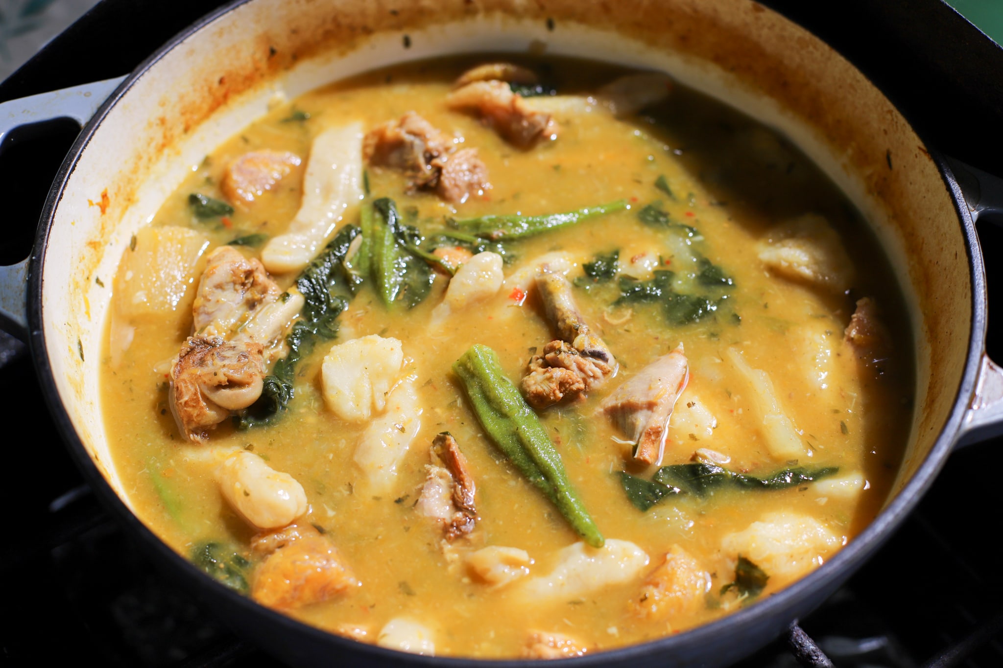 Caribbean Soup with chicken okra bhaji dumpling plantain showing in a soup pot