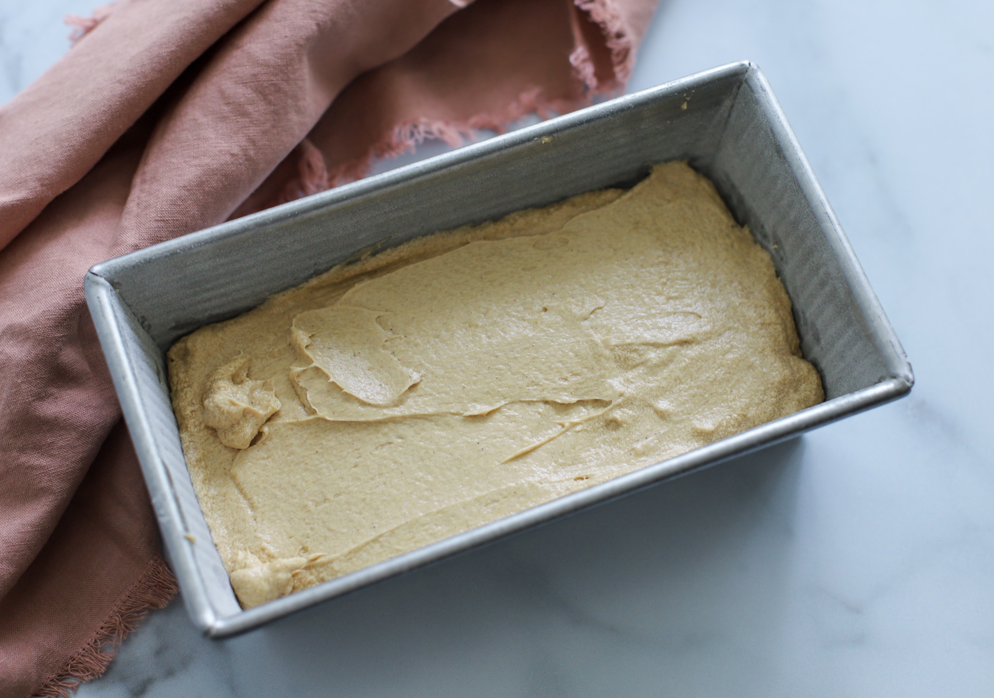 This photo shows the cake batter in a 9x4 baking pan ready to go into the oven