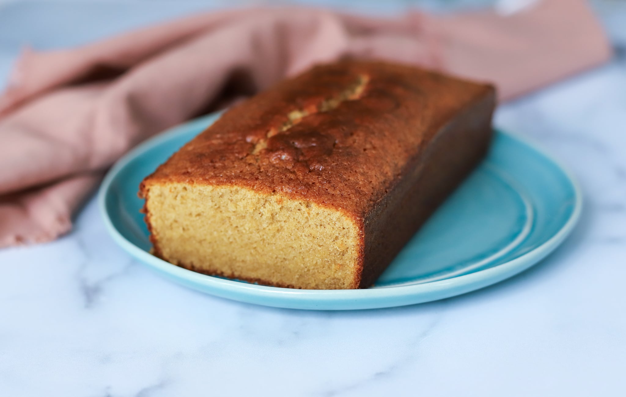 Inside view of West Indian sponge cake in a blue plate near a pink napkin