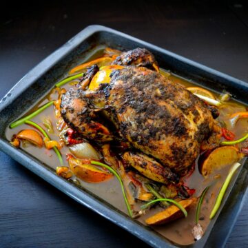 whole jerk chicken in a roasting pan