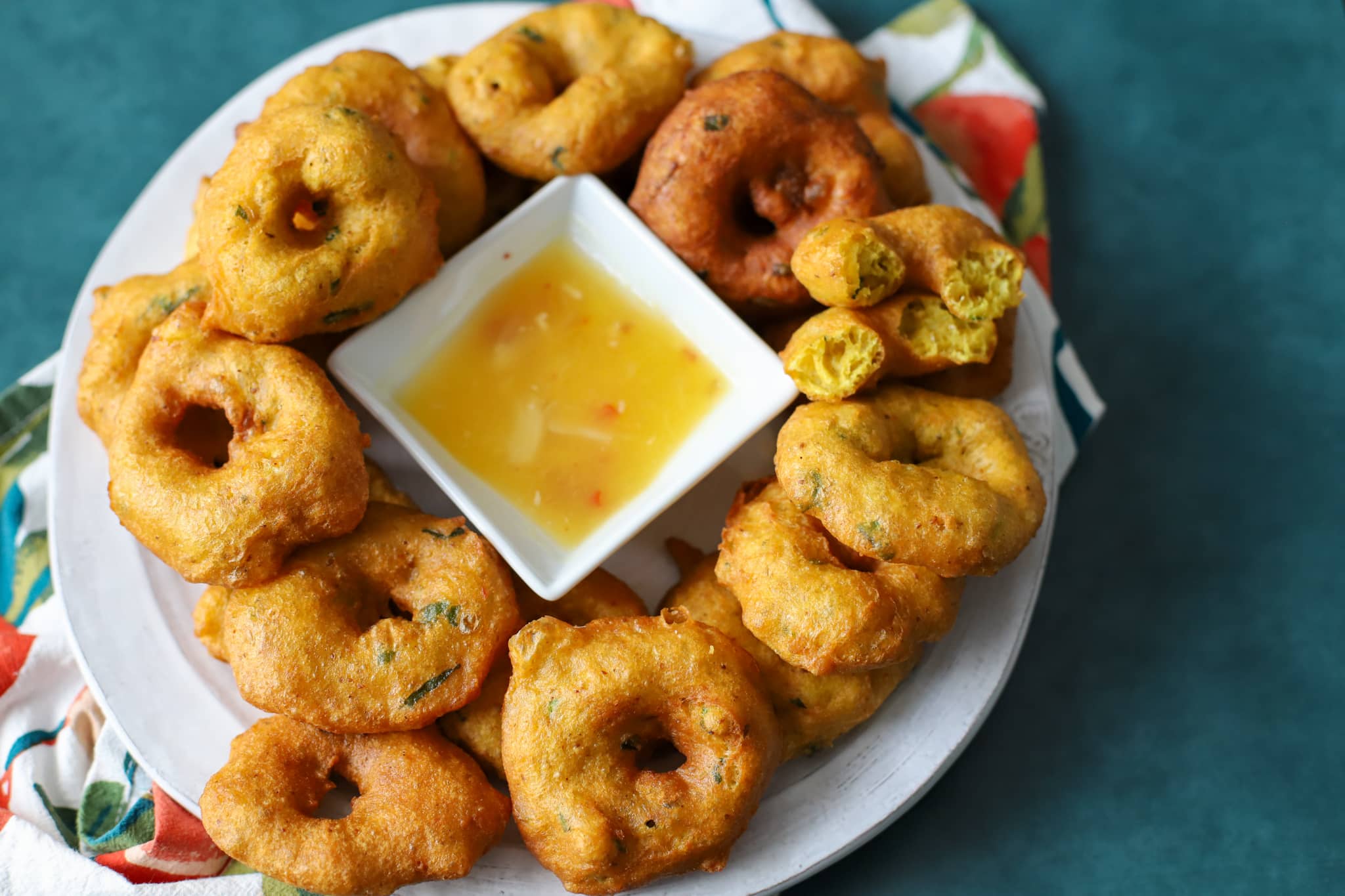 Guyanese bara in a white platter with a square bowl filled with mango sour. The platter is on a green background