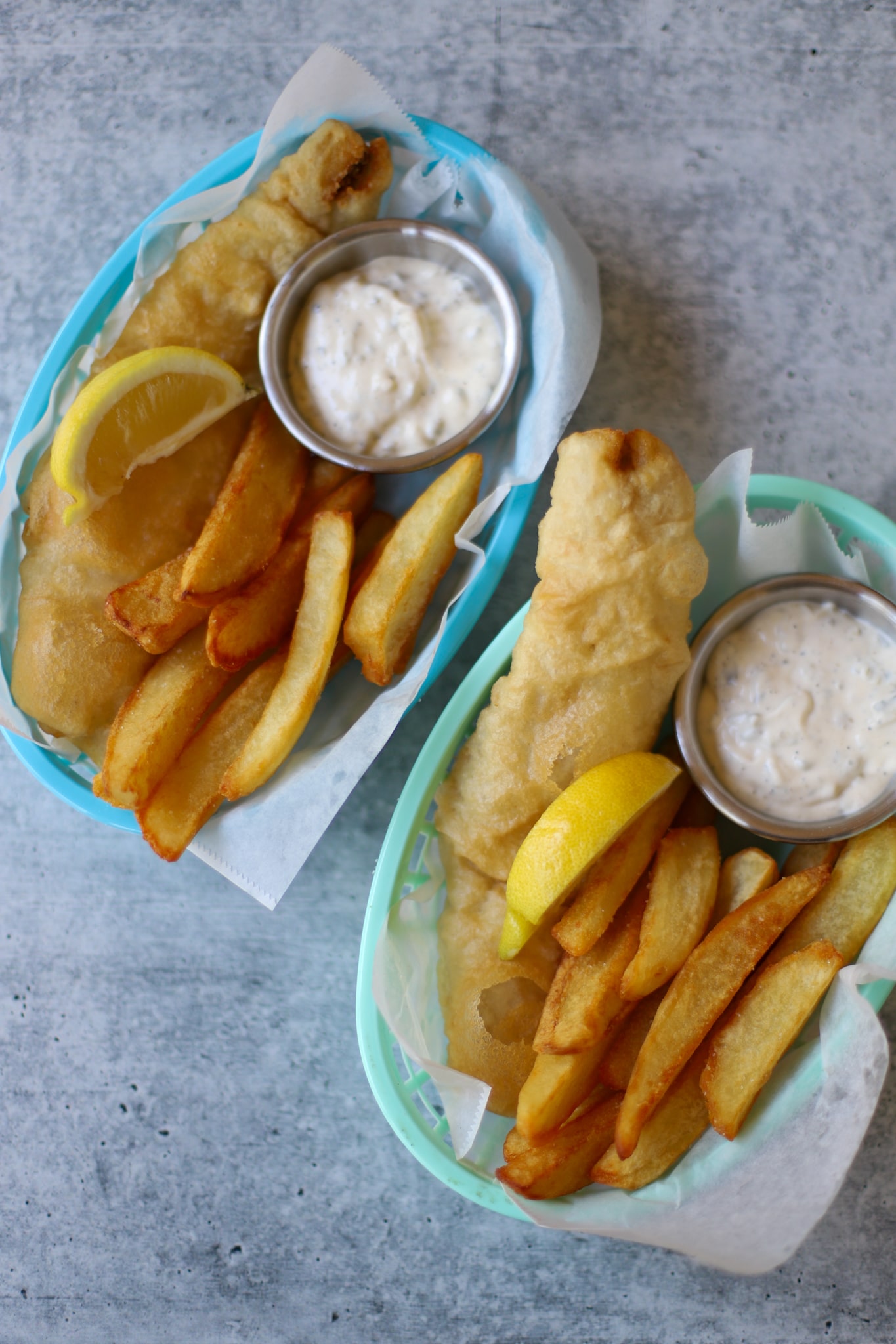 overhead image of fish and chips in blue mesh baskets
